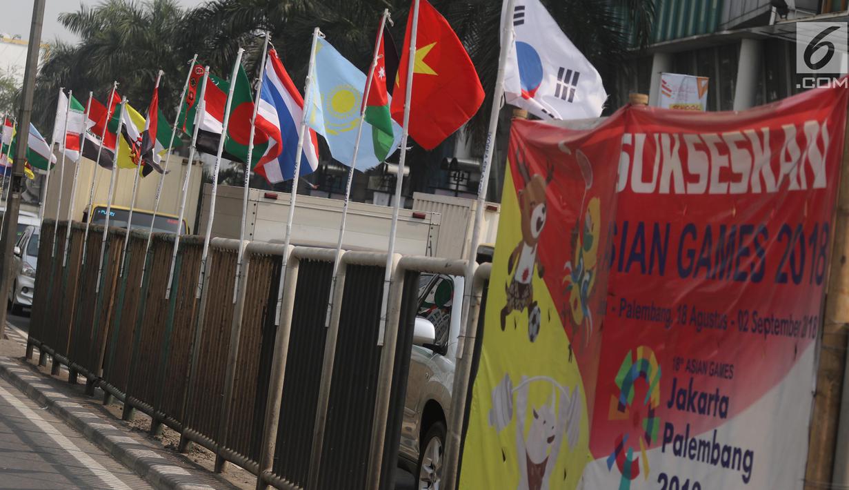 Deretan bendera negara-negara kontestan Asian Games 2018 yang terpasang menggunakan bambu di pagar pembatas Jalan Pluit Selatan Raya, Jakarta, Kamis (19/7). Bendera-bendera itu diikat di sebatang bambu yang dicat putih. (Liputan6.com/Arya Manggala)