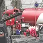 Petugas Pertamina menyedot sisa isi bahan bakar pada truk tangki yang terbakar di SPBU Jalan Kahfi 2, Jagakarsa, Jakarta, Sabtu (30/12). Pada saat terbakar, truk tangki diketahui memuat bahan bakar jenis pertalite. (Liputan6.com/Herman Zakharia)