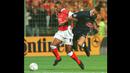 Striker Arsenal, Nicolas Anelka (kiri) berebut bola dengan bek RC Lens, Frederic Dehu pada laga penyisihan grup Liga Champions 1998/1999 di Lens, Prancis (16/9/1998). Nicolas Anelka yang telah pensiun sebagai pemain pada Januari 2016 bersama Mumbai City, tercatat pernah berseragam Arsenal selama 2,5 musim mulai tengah musim 1996/1997 hingga akhir musim 1998/1999. Gelar PFA Young Player of the Year diraihnya di musim terakhirnya pada 1998/1999. (AFP/Denis Charlet)