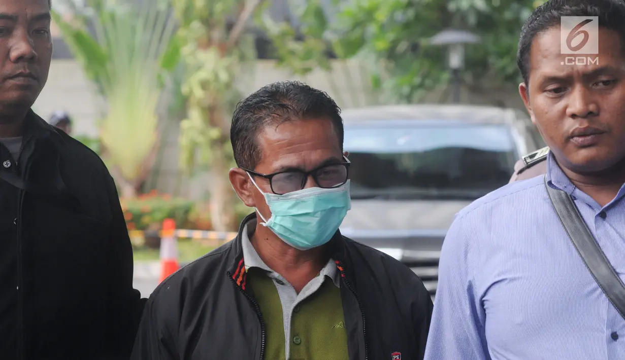 Bupati Mesuji Khamami (tengah) tiba di Gedung KPK, Jakarta, Kamis (24/1). Khamami memilih langsung masuk ke dalam lobi Gedung KPK dan menjalani pemeriksaan secara intensif. (Merdeka.com/Dwi Narwoko)