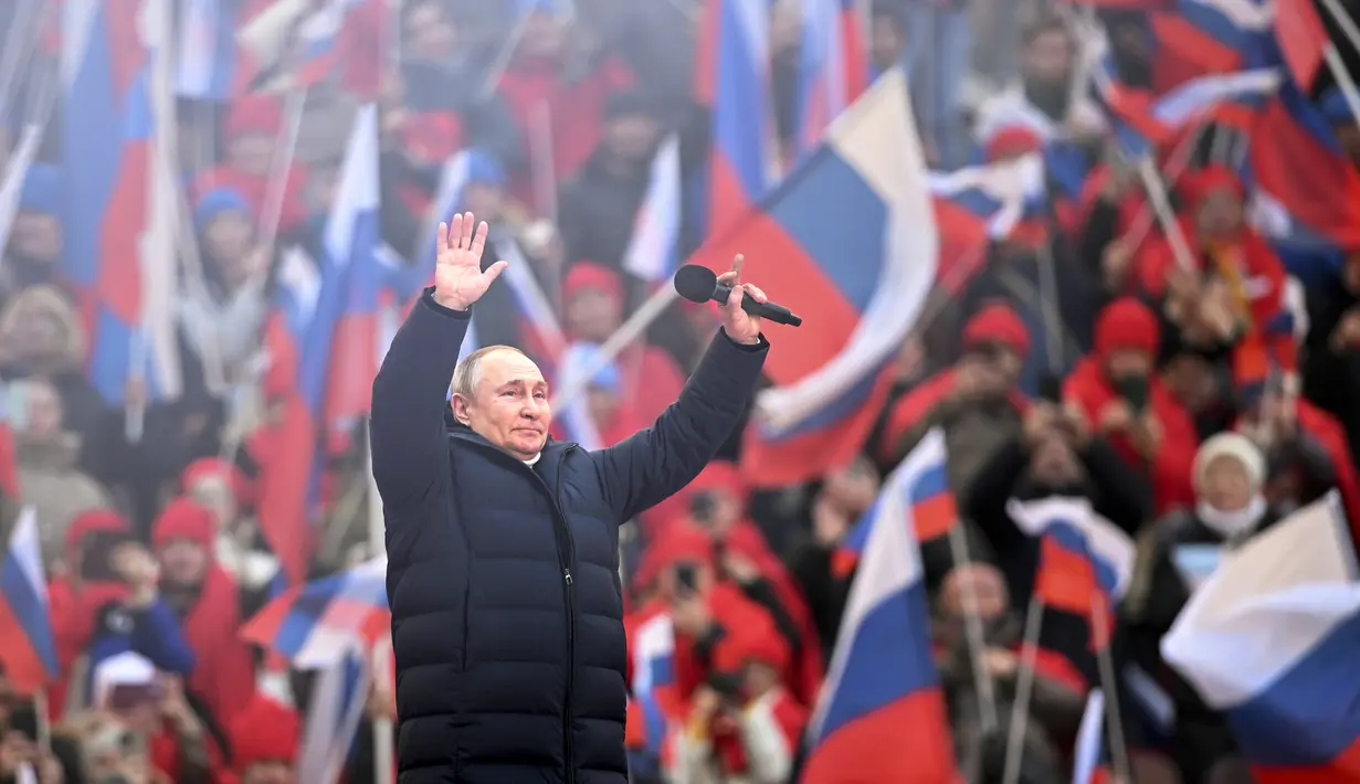 Presiden Rusia Vladimir Putin menyapa orang-orang setelah pidatonya di konser perayaan  delapan tahun referendum tentang status negara bagian Krimea dan Sevastopol serta penyatuannya kembali dengan Rusia, di Moskow, Rusia (18/3/2022). (Ramil Sitdikov/Sputnik Pool Photo via AP)