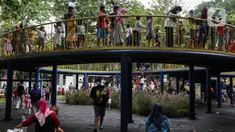 Anak-anak didampingi orang tua mereka bermain di Taman Puring, Jakarta, Minggu (9/1/2022). Di tengah ancaman penyebaran covid-19 varian Omicron dan pemberlakukan PPKM level 2, masyarakat tetap melakukan aktivitas pada akhir pekan di luar rumah. (Liputan6.com/Johan Tallo)