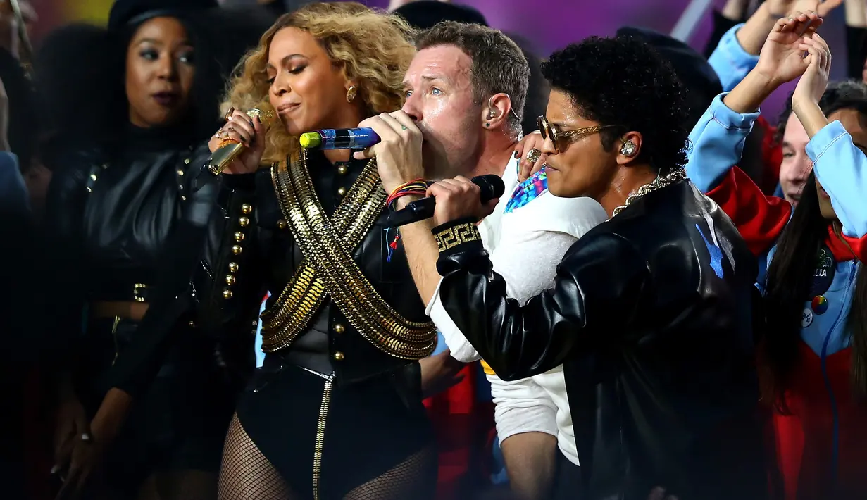 Penampilan penyanyi Beyonce, Chris Martin dari Coldplay dan Bruno Mars yang tampil pada halftime show Super Bowl 50 yang dihelat di Levi’s Stadium di Santa Clara, California, Minggu (7/2). (Ronald Martinez/Getty Images/AFP)