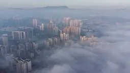 Foto udara ini menunjukkan bangunan yang diselimuti kabut pagi di Bijie, provinsi Guizhou barat daya China (18/11/2021).  Kota Bijie memiliki lintang rendah dan ketinggian di atas 1.700 m (5.600 kaki). (AFP/STR)