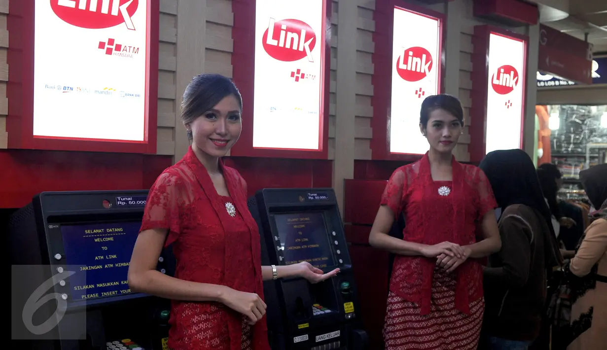 Dua model berdiri di depan mesin ATM Himbara Link saat peluncuran di pasar Tanah Abang, Jakarta, Senin (21/12). Bank-bank BUMN yang tergabung dalam Himbara adalah BRI, MANDIRI, BTN dan BNI. (Liputan6.com/Johan Tallo) 