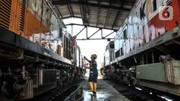 Petugas saat mencuci lokomotif kereta jarak jauh di Depo KA Cipinang, Jakarta Timur, Selasa (6/9/2022). Perawatan rutin itu terdiri atas tiga kategori antara lain pemeriksaan harian, bulanan, dan tahunan. (merdeka.com/Iqbal S Nugroho)