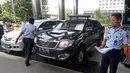 Petugas Rumah Penyimpanan Benda Sitaan Negara (Rupbasan) Jakarta Utara mengecek kondisi mobil sitaan di Gedung KPK, Jakarta, Selasa (30/1). Dalam kesempatan ini, KPK menyerahkan dua unit mobil sitaan. (Liputan6.com/Herman Zakharia)