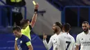 Bek Real Madrid, Sergio Ramos (tengah) menerima kartu kuning dari wasit Daniele Orsato saat melawan Chelsea dalam laga leg kedua semifinal Liga Champions 2020/2021 di Stamford Bridge, London, Rabu (5/5/2021). Real Madrid kalah 0-2 dari Chelsea. (AP/Alastair Grant)