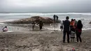 Orang-orang melihat bangkai ikan paus yang terdampar di sebuah pantai kawasan Rosarito, Meksiko, Senin (22/5). Bangkai paus tersebut membuat heboh dan menjadi pusat perhatian bagi pengunjung atau orang yang melintas. (AFP PHOTO/GUILLERMO ARIAS)