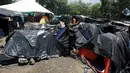 Seorang wanita migran asal Afrika yang terdampar di Kosta Rika berjalan di antara tenda-tenda di kamp darurat di perbatasan antara Kosta Rika dan Nikaragua, di Penas Blancas, Kosta Rika, (14/7). (REUTERS / Juan Carlos Ulate)