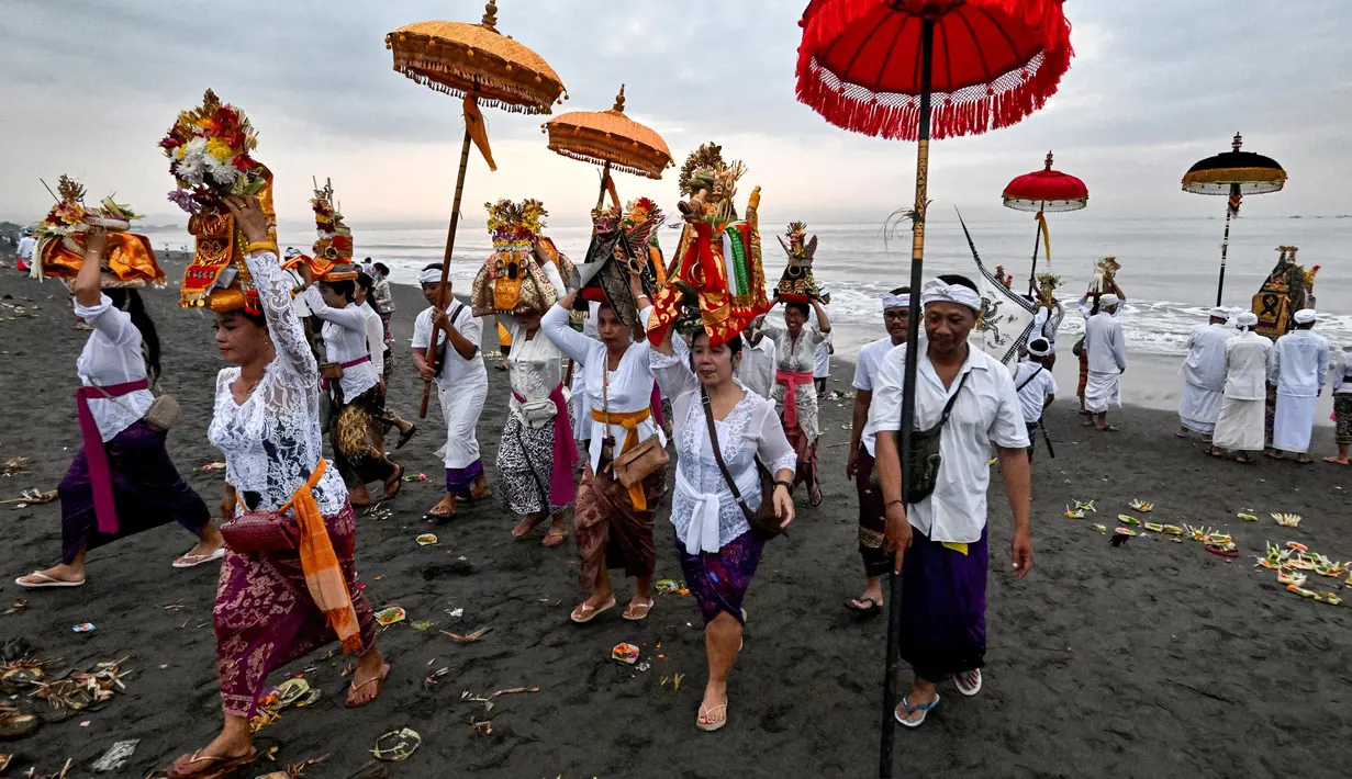 Upacara ini melibatkan prosesi orang-orang yang mengenakan pakaian tradisional Bali, membawa berbagai persembahan dan benda-benda suci. (Sonny TUMBELAKA/AFP)