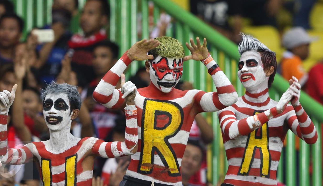 Beberapa suporter Madura United membuat lukisan badan saat menyaksikan timnya berlaga melawan Persija pada lanjutan Liga 1 di Stadion Patriot Candrabhaga, Bekasi, Kamis (4/5). Madura United FC unggul 1-0. (Liputan6.com/Helmi Fithriansyah)