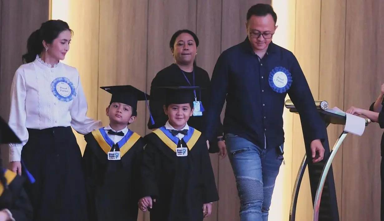 Pasangan yang menikah pada 1 September 2015 itu kompak menghadiri acara wisuda anak kembar mereka. Magha dan Degha terlihat begitu menggemaskan memakai baju wisuda lengkap dengan topi toganya. Untuk diketahui, anak sulung Kadek Devi terlahir kembar pada 25 April 2018 lalu. (Liputan6.com/IG/@dewayoga_07)