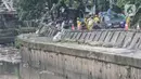Aktivitas perbaikan jalan amblas di Jalan Inspeksi Kali Ciliwung, Kenari, Jakarta, Rabu (19/1/2022). Jalan yang berada di belakang RSCM tersebut ambles sepanjang 40 meter akibat terkikis oleh hujan deras kemarin sehingga menyulitkan akses warga. (merdeka.com/Iqbal S Nugroho)