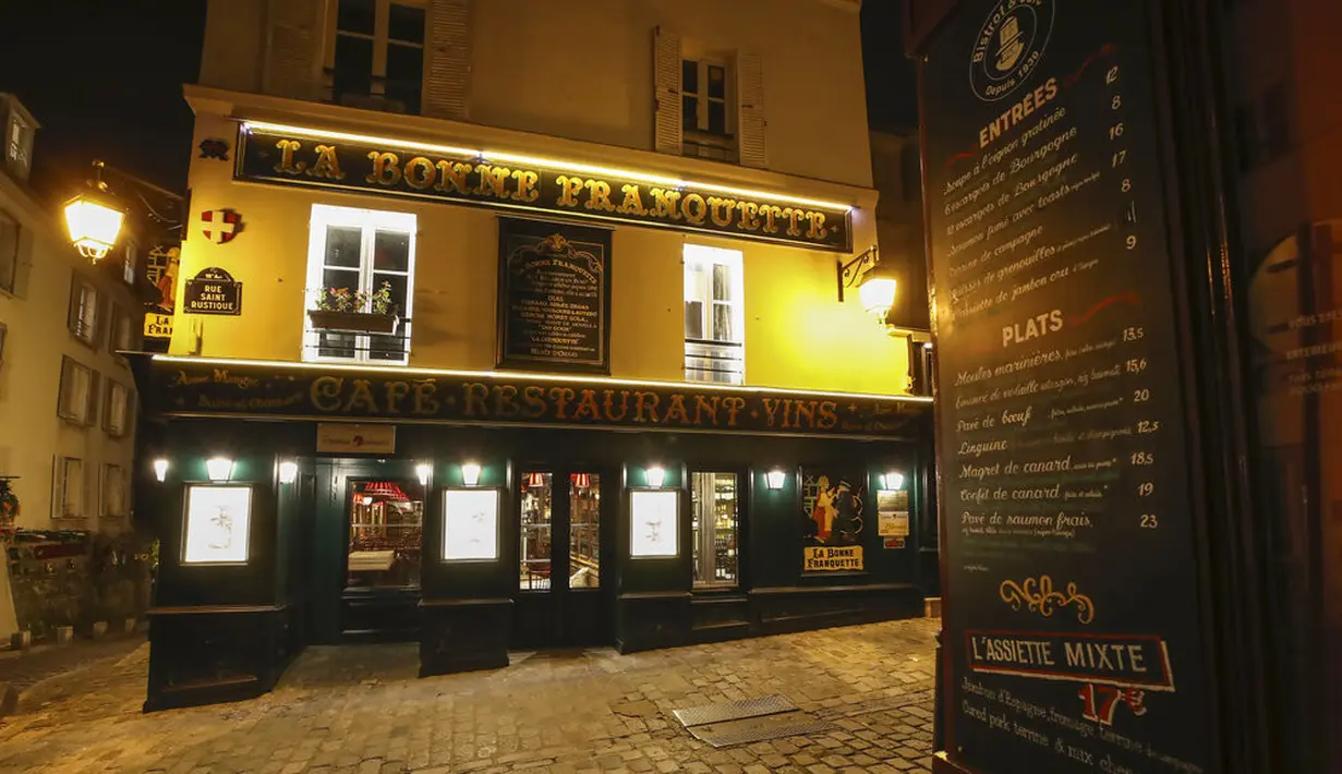 Sebuah papan menu terlihat pada samping restoran yang tutup selama jam malam di Montmartre, Paris, Perancis, Selasa (15/12/2020). Jam malam diberlakukan untuk mencegah lonjakan baru infeksi COVID-19. (AP Photo/Michel Euler)