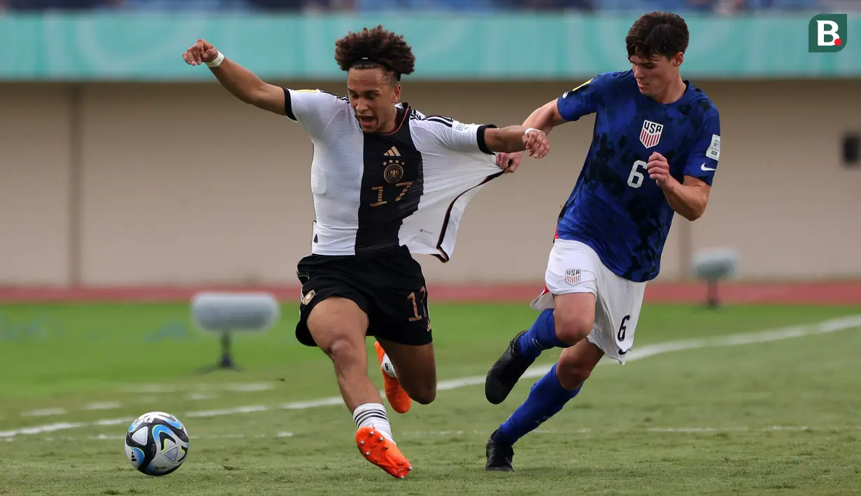 Pemain Timnas Jerman U-17, Eric Da Silva Moreira (kiri) berbut bola dengan pemain Timnas Amerika Serikat U-17, Matthew Corcoran pada laga 16 besar Piala Dunia U-17 2023 yang berlangsung di Si Jalak Harupat, Bandung, Selasa (21/11/2023). (Bola.com/Ikhwan Yanuar)