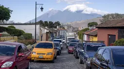 Kendaraan berbaris saat pekerja membersihkan puing-puing dari jalan setelah gempa bumi berkekuatan 6,2 skala Richter semalam di Antigua, Guatemala, 16 Februari 2022. Gempa bumi menyebabkan kerusakan yang mempengaruhi hampir 25.000 orang. (AP Photo/ Santiago Billy)