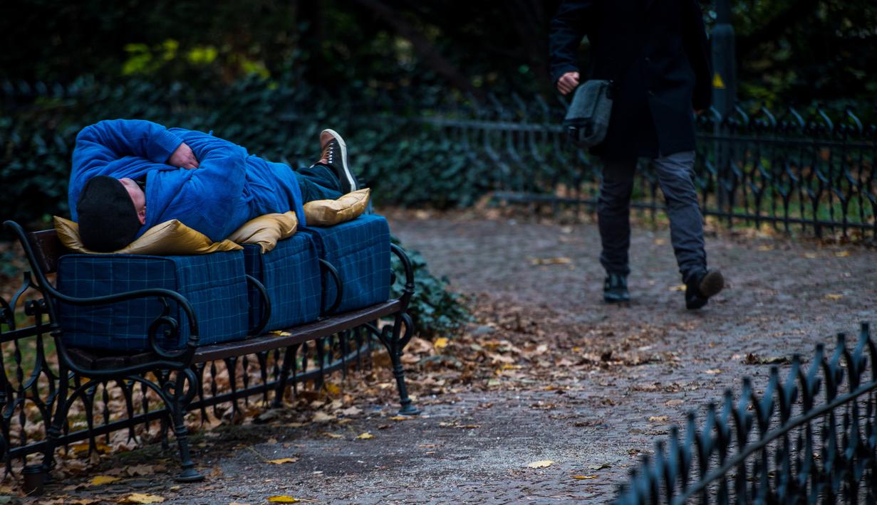 Aktivis berbaring di bangku di pusat kota Bratislava, 8 November 2018. Aksi itu untuk menunjukkan solidaritas kepada tunawisma di Hungaria yang dilarang tidur di tempat-tempat umum setelah diberlakukannya undang-undang tunawisma. (VLADIMIR SIMICEK/AFP)