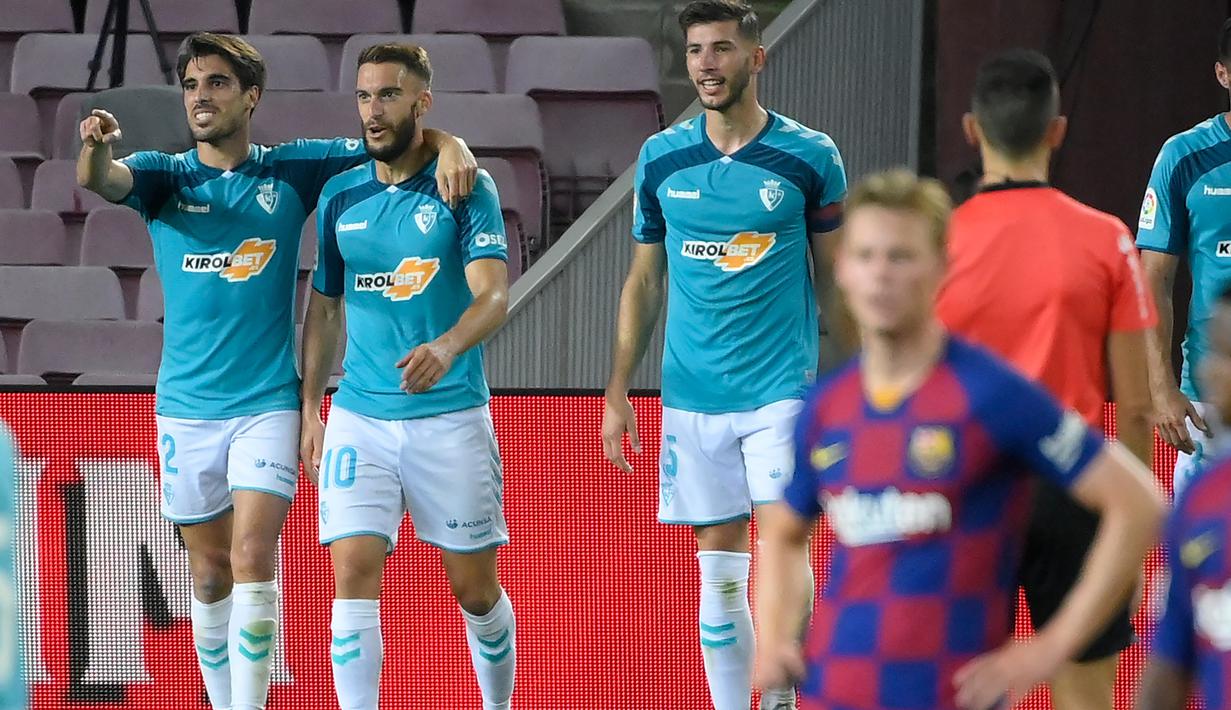 Pemain Osasuna merayakan gol yang dicetak Roberto Torres ke gawang Barcelona pada laga lanjutan La Liga pekan ke-37 di Camp Nou, Jumat (17/7/2020) dini hari WIB. Barcelona kalah 1-2 atas Osasuna. (AFP/Lluis Gene)