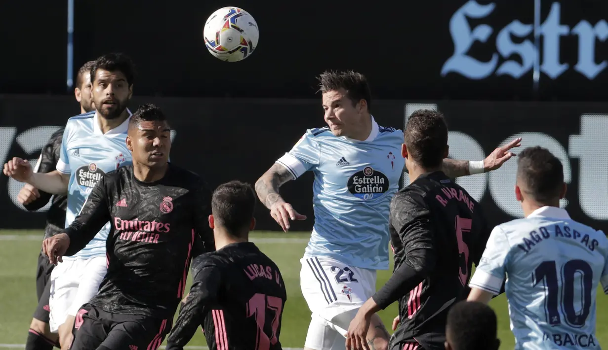 Striker Celta Vigo, Santi Mina (tengah) melepaskan sundulan yang berbuah gol ke gawang Real Madrid dalam laga lanjutan Liga Spanyol 2020/2021 pekan ke-28 di Balaidos Stadium, Sabtu (20/3/2021). Celta Vigo kalah 1-3 dari Real Madrid. (AP/Lalo R. Villar)
