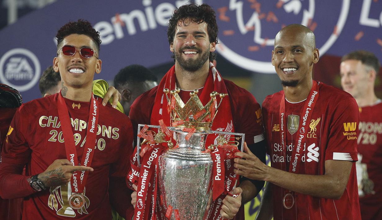 Pemain Liverpool, Roberto Firmino, Alisson Becker dan Fabinho, saat merayakan trofi juara Premier league 2019-2020 di Stadion Anfield, Kamis (23/7/2020) dini hari WIB. Prosesi angkat trofi juara ini dilakukan usai pertandingan Liverpool melawan Chelsea. (AFP/Phil Noble/pool)