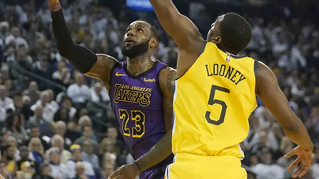Bintang LA Lakers, LeBron James (kiri) diadang pemain Golden State Warriors, Kevon Looney