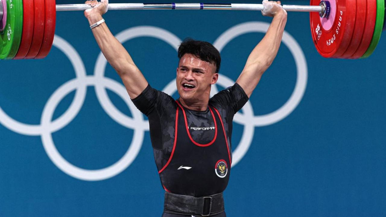 Aksi atlet angkat besi Indonesia, Rizki Juniansyah melakukan angkatan clean and jerk seberat 199 kg saat berdanding dalam nomor 73 kg putra Olimpiade 2024 Paris, Jumat (9/8/2024) dini hari WIB. Berkat perjuangan kerasnya,&nbsp;Rizki berhasil meraih medali