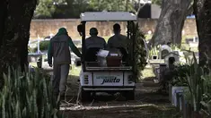 Petugas mengangkut peti jenazah Jose Valdelirio yang diyakini meninggal akibat virus corona di pemakaman Campo da Esperanca di Taguatinga, Brasilia, Brasil, Rabu (3/3/2021). Brasil pada Selasa (2/3) mencatat rekor tertinggi dengan 1.641 kematian akibat Covid-19 dalam 24 jam. (AP Photo/Eraldo Peres)
