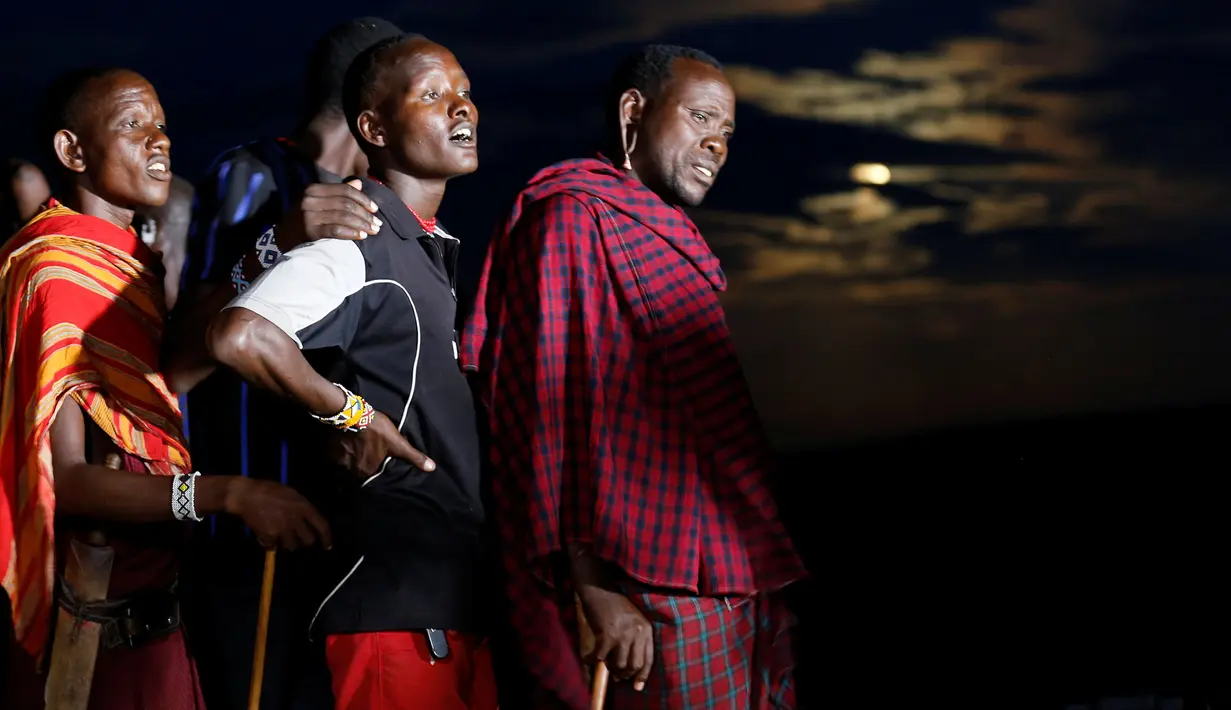 Sejumlah pria suku Maasai mengantre untuk menyaksikan fenomena supermoon dengan teleskop di desa Oloika, Shompole, perbatasan Kenya-Tanzanian border, (14/11). Fenomena ini paling dekat dengan Bumi pada jarak 356.509 kilometer. (REUTERS/Thomas Mukoya)