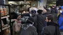 Orang-orang mengantre untuk mendapatkan roti di dalam toko roti di pinggiran selatan Beirut, Dahiyeh, Lebanon, pada 15 Maret 2022. Melonjaknya harga energi dan makanan yang dipicu oleh invasi Rusia ke Ukraina mendorong beberapa negara Timur Tengah ke tepi jurang. (AP Photo/Bilal Hussein)