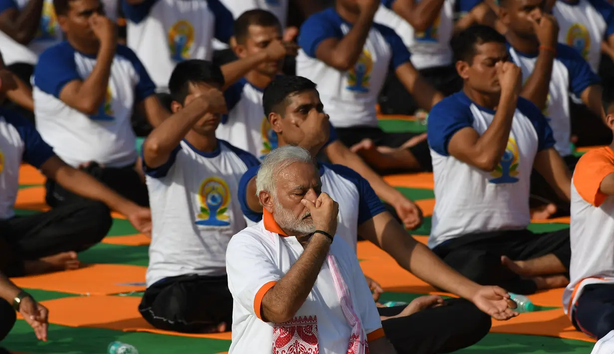 Perdana Menteri India, Narendra Modi memimpin pelaksanaan yoga massal pada Hari Yoga Internasional di Dehradun, Kamis (21/6). Modi adalah tokoh utama yang berhasil melobi PBB untuk menyatakan 21 Juni sebagai Hari Yoga Internasional. (AFP/PRAKASH SINGH)