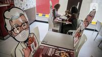 Banner bergambar karakter terlihat di KFC Salemba, Jakarta, Selasa (23/6/2020). Banner bergambar tersebut berguna untuk pembatas bagi pengunjung yang makan di tempat saat fase kenormalan baru. (Liputan6.com/Faizal Fanani)