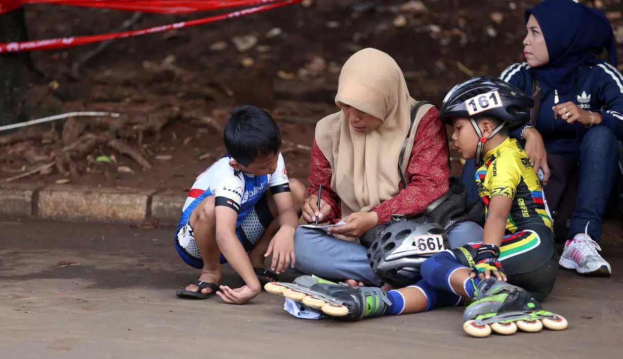 Dua orang Bocah mendengarkan arahan orang tua dalam kejuaraan Invitasi Sepatu Roda DKI Jakarta di Senayan, Jakarta, Minggu (8/11/2015). Kejuaraan ini diikuti sekitar 39 klub seluruh Indonesia. (Bola.com/Nicklas Hanoatubun).