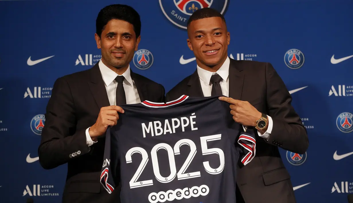 Striker Paris Saint-Germain (PSG) Kylian Mbappe (kanan) menunjukkan jerseynya dengan Presiden PSG Nasser Al-Khelaifi saat konferensi pers di Stadion Paris des Princes, Paris, Prancis, 23 Mei 2022. Keputusan Kylian Mbappe menolak Real Madrid dan berkomitmen untuk PSG selama tiga musim lagi menandai dimulainya proyek pembangunan klub juara Liga Prancis tersebut. (AP Photo/Michel Spingler)