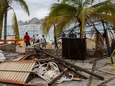 Sejumlah warga berdiri di puing-puing sebuah restoran setelah hantaman Badai Newton di Los Cabos, Meksiko, Selasa (6/9). Menurut otoritas berwenang, Badai Newton telah mengakibatkan dua orang meninggal dan tiga lainnya hilang. (REUTERS/Fernando Castillo)
