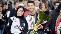 Cristiano Ronaldo bersama kekasihnya, Georgina Rodriguez, berpose dengan trofi Serie A di Stadion Allianz, Turin (19/5/2019). (AFP/Marco Bertorello)