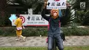 Aktivis WALHI memakai topeng orangutan saat menggelar aksi di depan Gedung Bank of China, Jakarta, Jumat (1/3). Aksi ini digelar jelang putusan PTUN Medan terkait gugatan WALHI terhadap izin lingkungan PLTA Batang Toru. (Liputan6.com/Fery Pradolo)