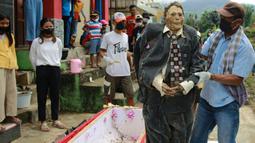 Keluarga melakukan ritual adat Manene di Desa Pangala, Toraja Utara, Sulawesi Selatan, 27 Agustus 2021. Manene merupakan upacara turun temurun masyarakat Toraja sebagai bentuk penghormatan kepada leluhur mereka yang telah wafat. (SEVIANTO PAKIDING/AFP)