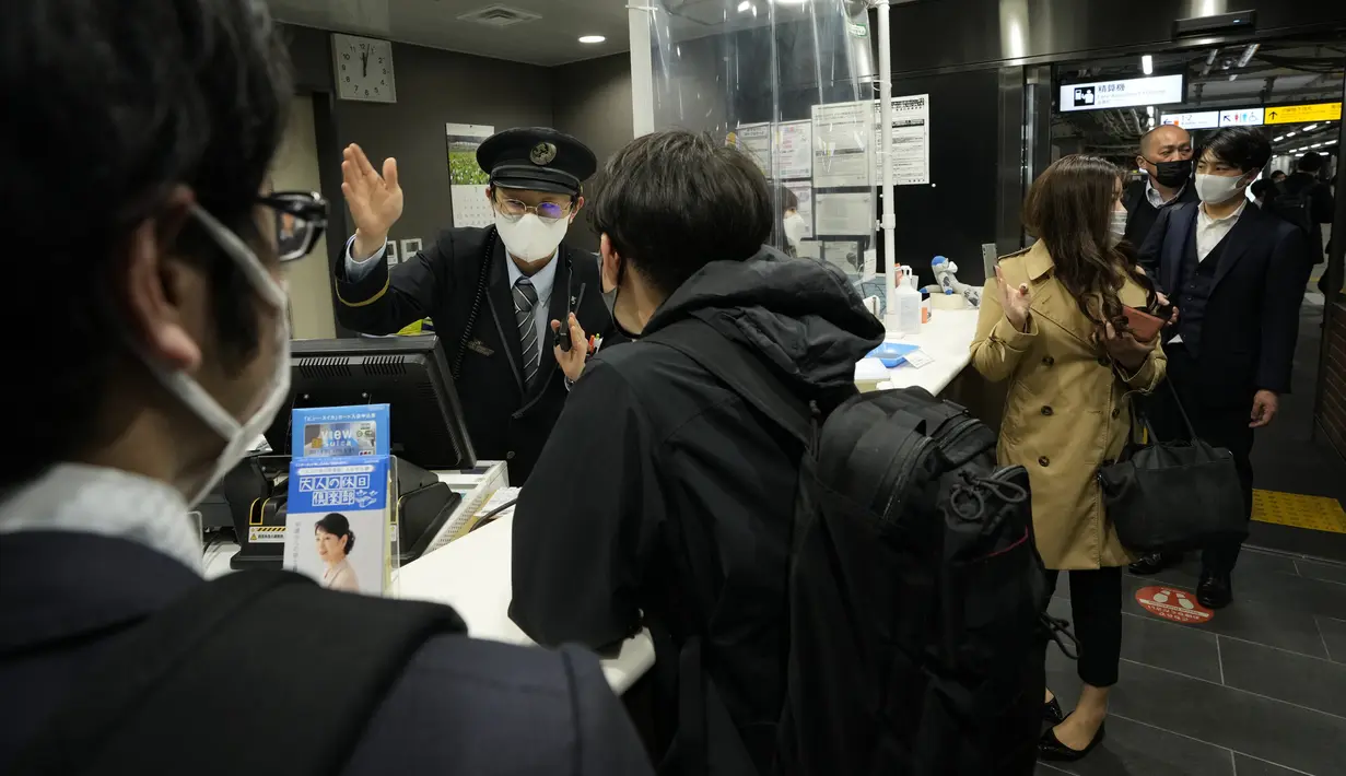 Kepala stasiun membantu pelanggan saat layanan perjalanan dihentikan setelah gempa bumi di stasiun kereta Tokyo di Tokyo, Kamis (17/3/2022) pagi. Gempa kuat Magnitudo 7,3 mengguncang lepas pantai Fukushima di Jepang utara pada hari Rabu (16/3), memicu peringatan tsunami. (AP Photo/Hiro Komae)