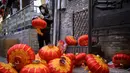 Seorang pekerja memasang lentera tradisional Tiongkok di sepanjang gang menjelang Tahun Baru Imlek di Beijing, China, 2 Februari 2021. Imlek tahun ini jatuh pada tanggal 12 Februari 2021. (NOEL CELIS/AFP)