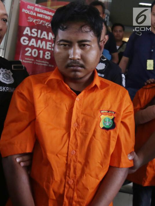 Pelaku pembunuhan wartawan Abdullah Fitri Setiawan yang tewas dalam drum M Nurhadi digiring petugas di Bogor di Polda Metro Jaya, Jakarta, Rabu (21/11). Kedua pelaku dijerat pasal pembunuhan berencana dan terancam hukuman mati. (Merdeka.com/Imam Buhori)