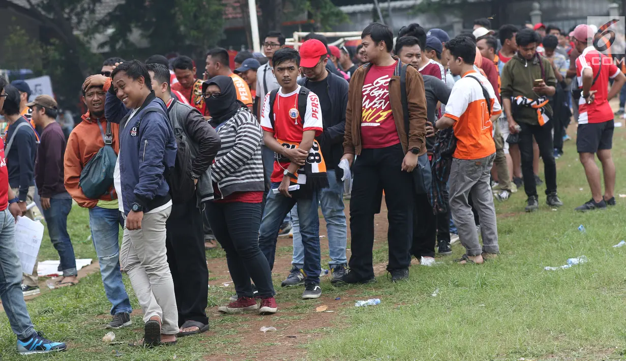 Suporter tim Persija mengantre menukarkan voucher on-line dengan tiket masuk Stadion GBK di Lapangan Blok S, Jakarta, Minggu (9/12). Mereka akan menyaksikan laga penentuan gelar juara Persija di Liga 1 Indonesia 2018. (Liputan6.com/Helmi Fithriansyah)