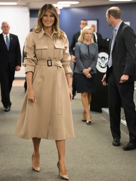 Ibu Negara AS, Melania Trump melakukan pertemuan di Kantor Pusat Penanggulangan Bencana setelah hampir satu bulan absen di Washington, Rabu (6/6). Melania tampil seperti biasanya dengan mantel cokelat dilengkapi ikat pinggang. (AP/Andrew Harnik)