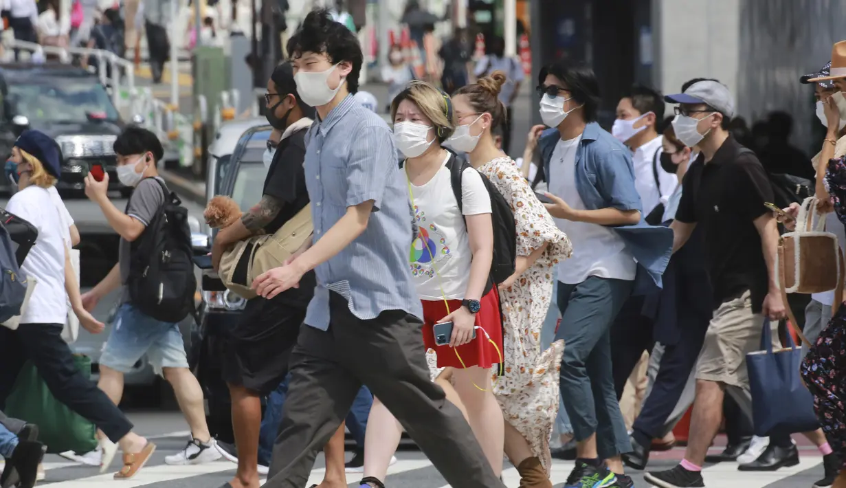 Orang-orang yang memakai masker untuk membantu melindungi diri dari penyebaran virus corona berjalan melintasi persimpangan di Tokyo, Senin (30/8/2021). Total nasional, Jepang mencatatkan 1,4 juta kasus dan 15.851 kematian akibat COVID-19. (AP Photo/Koji Sasahara)