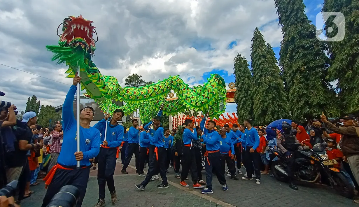 Atraksi tarian naga memeriahkan karnaval  budaya saat Festival Grebeg Sudiro di kawasan Pasar Gede, Surakarta, Jawa Tengah, Minggu ( 19/1/2020). Grebeg Sudiro merupakan acara tahunan untuk menyambut Tahun Baru Imlek. (Liputan6.com/Gholib)