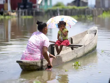 Seorang wanita mendayung sampan bersama putrinya di Cienaga Grande de Santa Marta, Nueva Venecia, Kolombia, 12 Oktober 2021. Sekitar 400 keluarga tinggal di rumah panggung di Cienaga Grande. (AP Photo/Fernando Vergara)