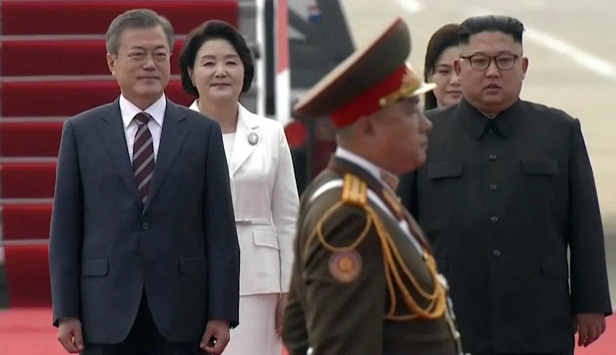 Presiden Korea Selatan, Moon Jae-in didampingi istrinya Kim Jung-sook berjalan bersama pemimpin Korea Utara, Kim Jong-un didampingi sang istri, Ri Sol Ju setibanya di Pyongyang, Selasa (18/8). (Korea Broadcasting System via AP)