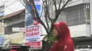 Seorang pengguna jalan melintasi benner ilklan beli apartemen dapat suami di kawasan Nonongan, Solo (3/2/2016). Iklan di pasang untuk menarik minat calon pembeli. (Liputan6.com/Boy Harjanto)