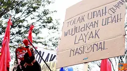 Seorang demonstran memainkan golek pada aksi penolakan sistem kerja kontrak dan outsourcing, dalam rangka Hari Buruh Internasional, di depan Kantor Gubernur Jabar, jalan Diponegoro, Kota Bandung, Minggu (1/5). (Aries Rachmandy)  