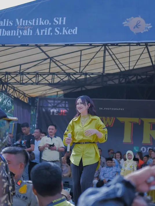 Seperti potret ini, pelantun lagu “Dalan Liyane” itu tampil modis dengan padanan kemeja, belt, dan celana plisket. [Foto: IG/happy_asmara77].